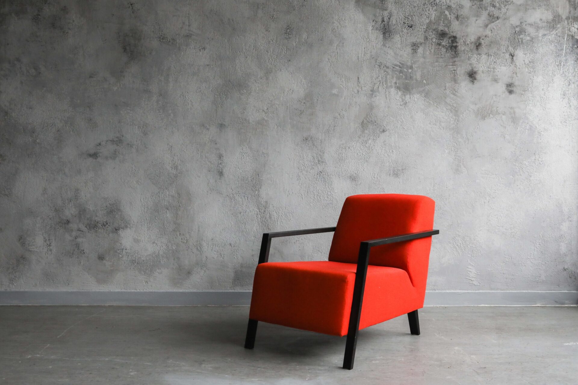 Concrete venetian plaster feature wall with red chair in London